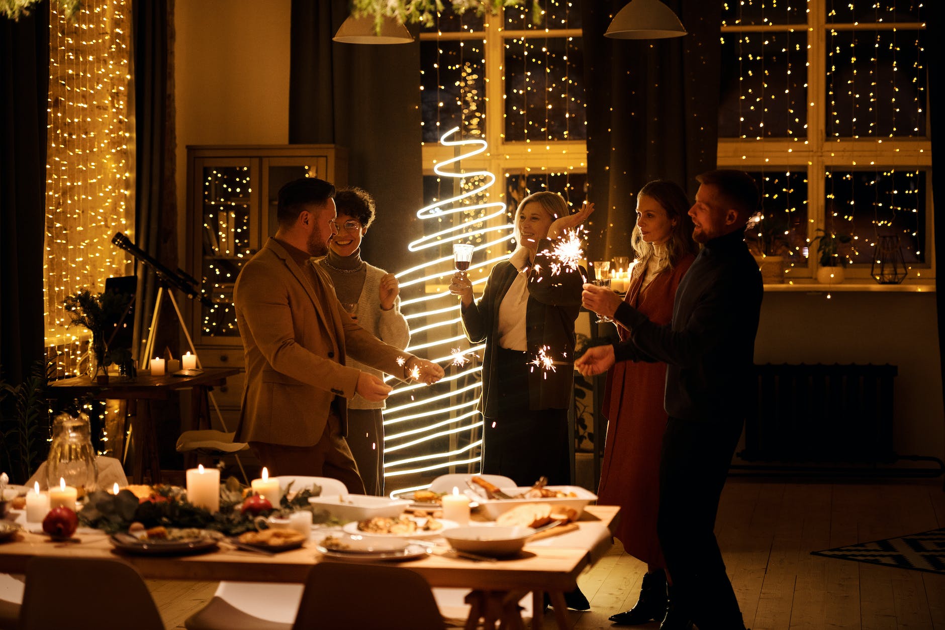 family celebrating christmas while holding burning sparklers