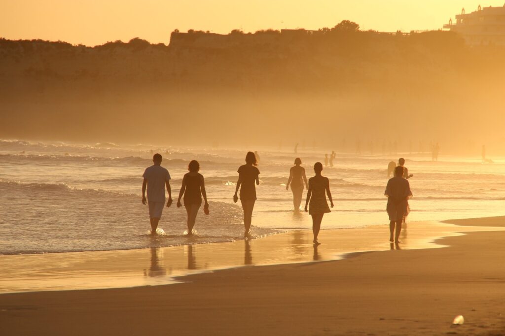 people walking by the beach, a good location for property swapping