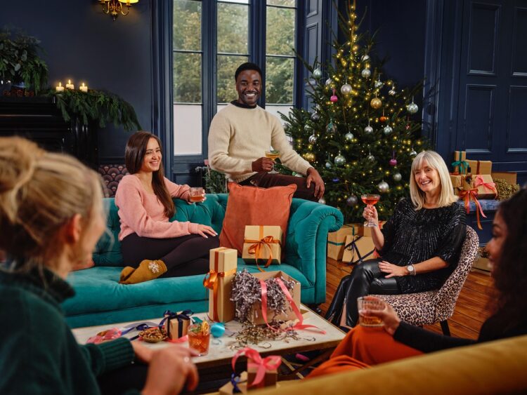 family and friends sharing a drink and Christmas gifts